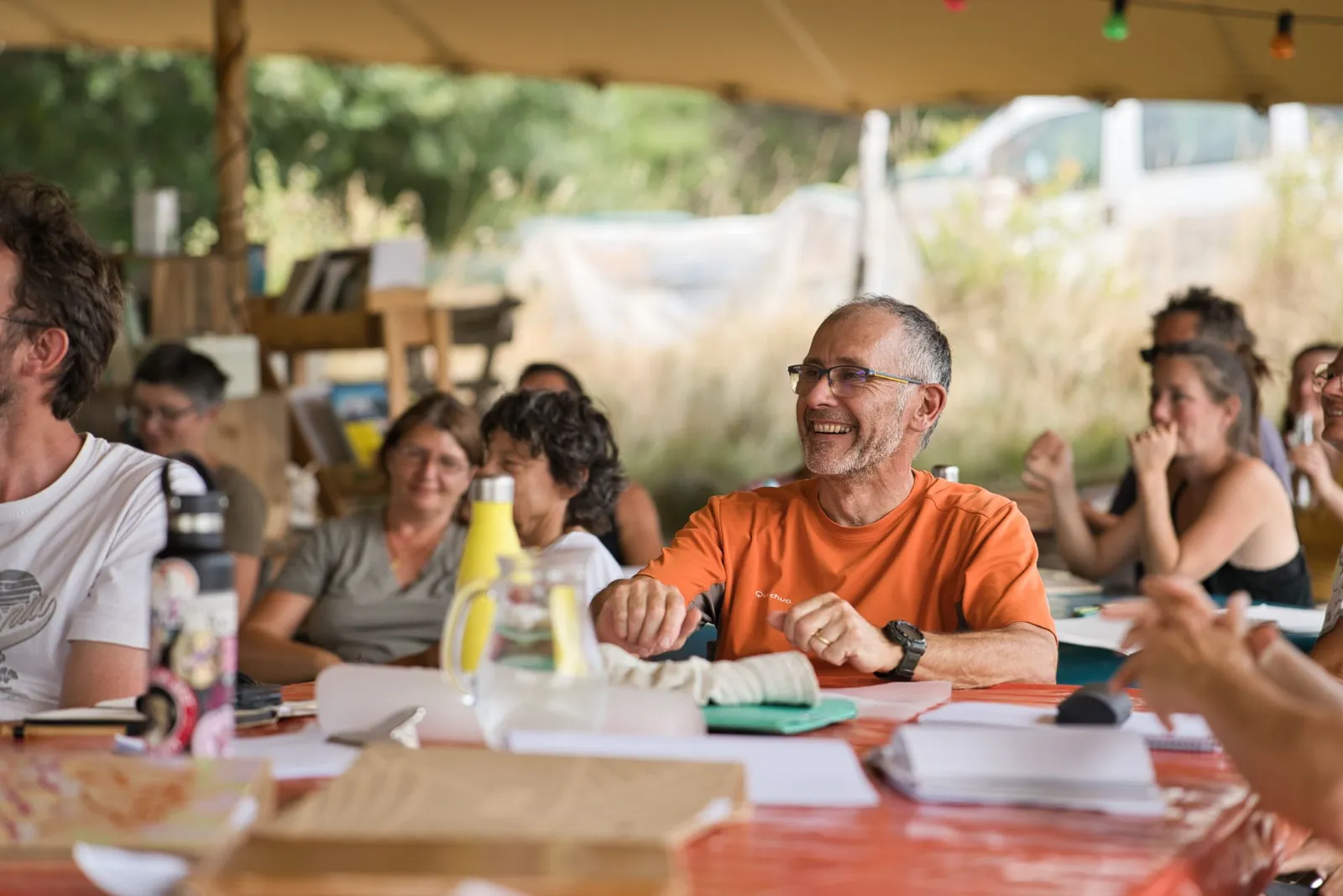 Formateur souriant entouré de stagiaires autour d'une table