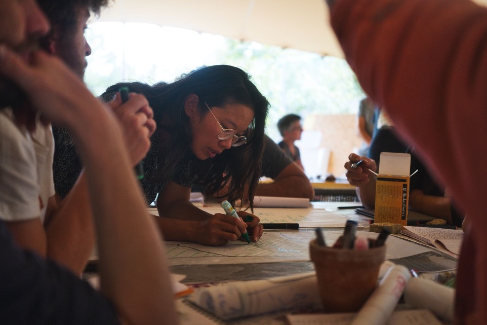 Stagiaires travaillant sur leurs designs autour d'une table